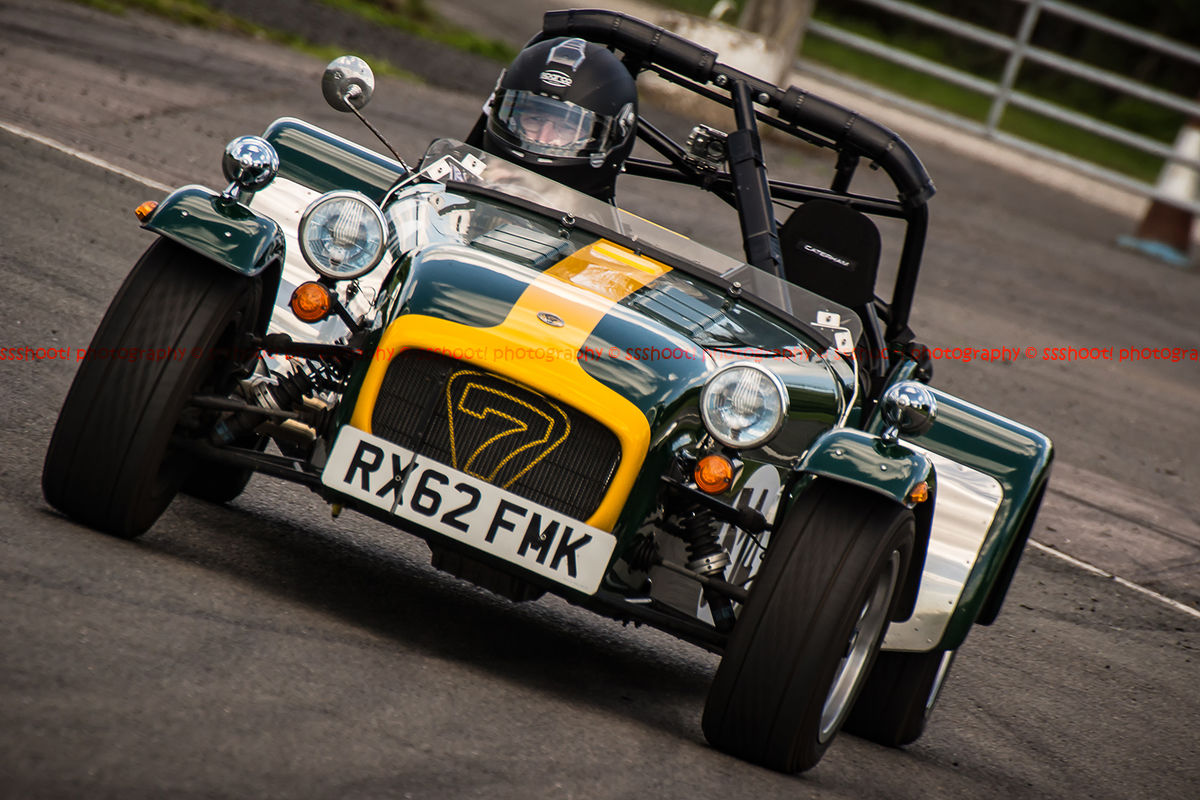 yellow and green caterham 7 rounding the fradley hairpin corner at curborough sprint track