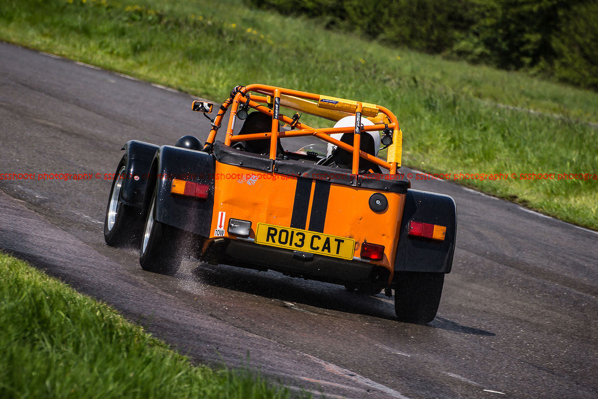 Orange Lotus 7 Caterham Westfield opposite lock in rain at Curborough Sprint Course