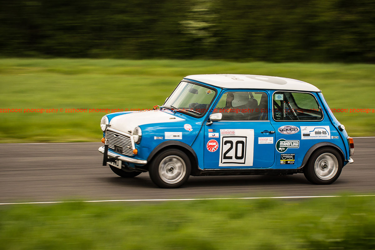 classic blue mini cooper s at speed along shenstone straight