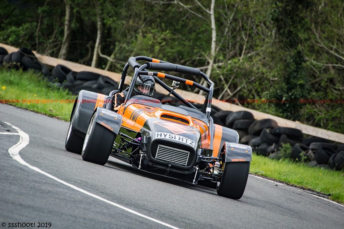orange and black lotus 7 caterham westfield at speed through molehill corner at curborough sprint track