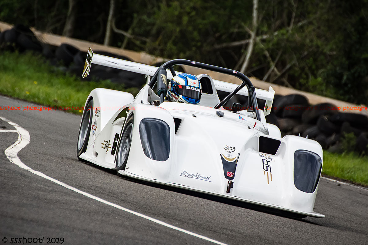 white radical race car at speed through molehill corner at curborough sprint track