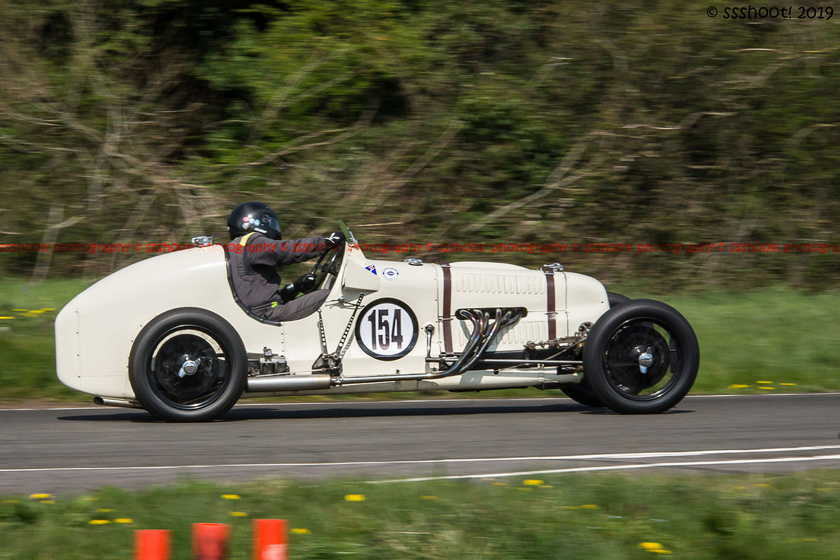 White vinage racing car taking on curborough sprint course at speed