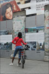 Girl on her bicycle at the wall.