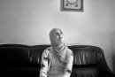 Muslim veiled girl sitting in a room on the couch