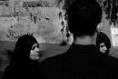 Man, seen from behind, looks at 2 women
