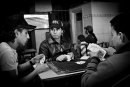 3 teenagers play cards at the cafe