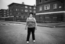 Portrait of female resident of St. Teresas Gardens, blocks in the background