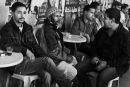 4 men sit in a cafe