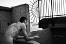 Bathing place Topless Man  looks at the sea through the metal bars