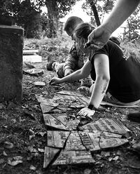Woman and man gathering together the broken pieces of old German tombstone
