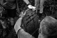 Man holds the old German tombstone