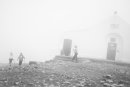 People circle around Croagh Patrick chapel in the fog