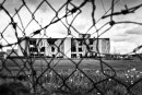 Closed factory or warehouse is seen through the fence