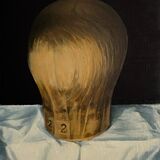 An oil painting of a wooden milliner's model on a white tablecloth