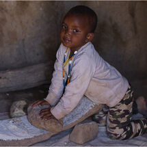 Boy grinding corn - H/C