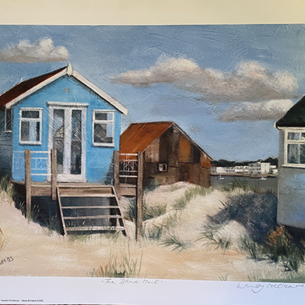 Print of a blue beach hut on Mudeford Sandbank Spit with a view of Christchurch behind