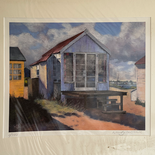 Mounted print of a tin beach hut on Mudeford Sandbank Spit under a cloudy sky