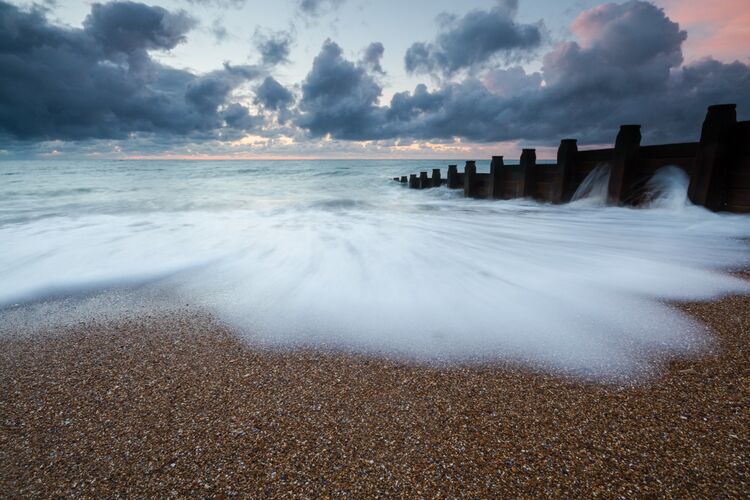 Waves crashing up the beach during sunrise