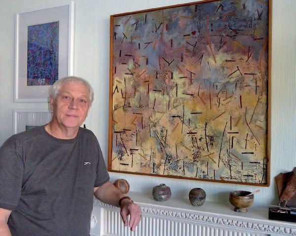 David poses with one of his paintings from the 1980s called Forest Fire